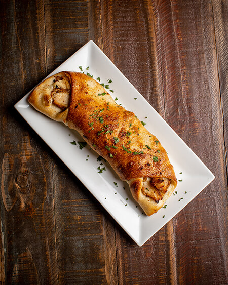 A beautifully presented Chicken Roll on a wooden counter — $7.50