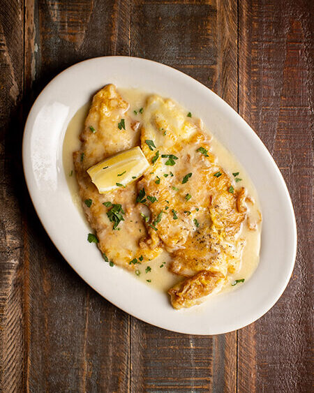 A beautifully presented plate of flounder francese or marechiare on a wooden counter — $18.95