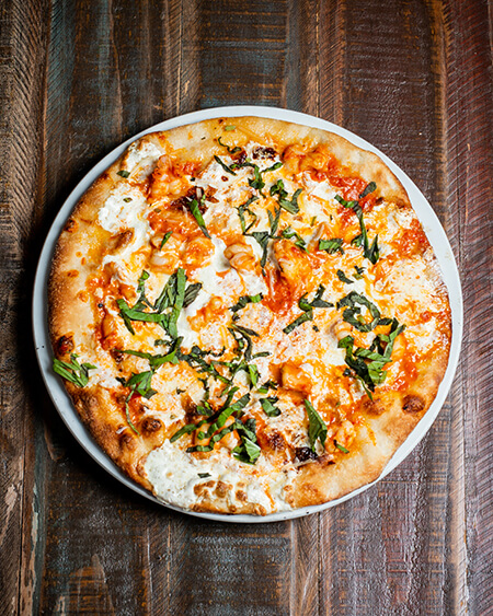 Gourmet Gamberi pizza is Mozzarella cheese, fresh mozzarella cheese, sauteed shrimp, vodka sauce, and basil
