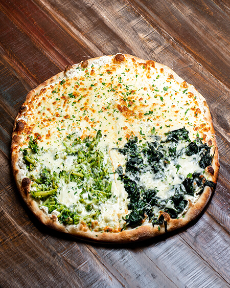 A beautifully presented White Pizza pizza pie on a wooden counter — $17.60